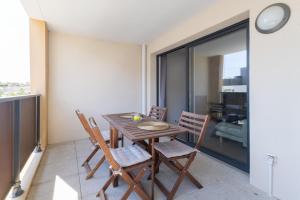 een eetkamer met een houten tafel en stoelen bij La Terrasse de Duranne - Accès rapide TGV Aéroport in Aix-en-Provence