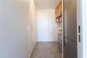 a small kitchen with white walls and a hallway at La Baie des Anges - Plage à Pied - Garage Privé in La Ciotat +2 photos
