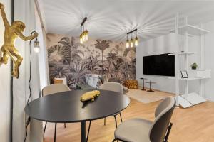 a dining room with a table and chairs and a tv at Luxury Cosmopolit Apartments in the Heart of Brasov in Braşov