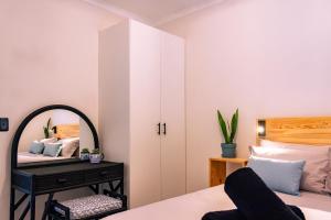 a bedroom with a bed with a mirror and a table at S Haven Luxury Self Catering Apartment in Franskraalstrand