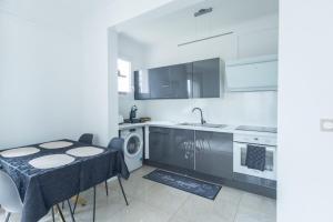 a kitchen with a table and a sink and a dishwasher at Le Cocon d'Allauch - T3 avec jardin in Allauch