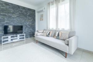 a living room with a couch and a tv at Le Cocon d'Allauch - T3 avec jardin in Allauch