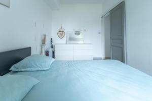 a bedroom with a large white bed with a door at Le Cocon d'Allauch - T3 avec jardin in Allauch +13 photos