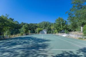 a tennis court with trees in the background at Villa Wagner - Aix en Provence in Les Platrières