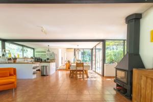 Villa sur Domaine Aix - Piscine & Tennis - Wagner في Les Platrières: مطبخ مفتوح وغرفة معيشة مع موقد +35 صورة