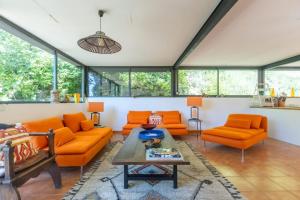 a living room with orange furniture and windows at Villa Wagner - Aix en Provence in Les Platrières +35 photos