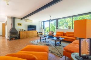 a living room with orange furniture and a tv at Villa Wagner - Aix en Provence in Les Platrières