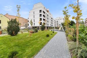 a walkway in front of a building with a green yard at Luxury Cosmopolit Apartments in the Heart of Brasov in Braşov
