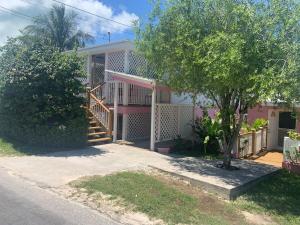 a pink house with a staircase in front of it at Tickled Pink in Harbour Island