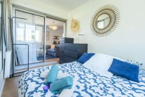 ein Schlafzimmer mit einem blau-weißen Bett mit einem Spiegel in der Unterkunft Magnifique T2 - Centre Sanary & Parking privé - Senaya in Sanary-sur-Mer + 12 Fotos