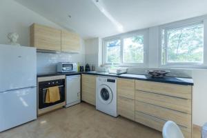 a kitchen with a white refrigerator and a dishwasher at Appartement sur Domaine Aix - Piscine Tennis - Mozart in Aix-en-Provence