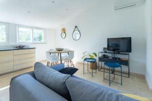 a living room with a blue couch and a table at Appartement sur Domaine Aix - Piscine Tennis - Mozart in Aix-en-Provence