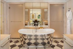a bath tub in a bathroom with a shower at Hôtel Métropole Monte-Carlo - Spa Guerlain in Monte Carlo +104 photos