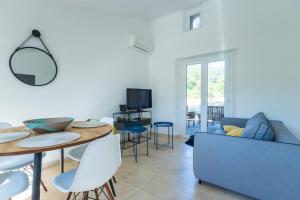 a living room with a blue couch and a table at Appartement sur Domaine Aix - Piscine Tennis - Mozart in Aix-en-Provence +14 photos