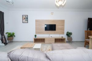 レッキにあるArzumiの白いソファと薄型テレビのあるリビングルーム