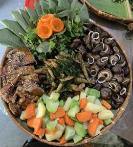 un plato de comida con verduras, carne y champiñones en Homestay Hoanh Thắng, en Lũng Tiềm 19 fotos más