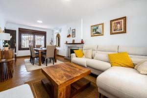 een woonkamer met een bank en een tafel bij Casa en Cabo de Gata con barbacoa y Jardín, cerca de la playa in El Cabo de Gata
