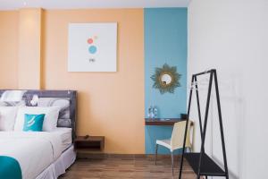 una camera da letto con un letto e una scrivania con una sedia di Sans Hotel Cemara Asri Medan a Pulauberayan Dadap