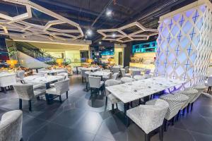 a dining room with white tables and chairs at Vivatel Kuala Lumpur in Kuala Lumpur