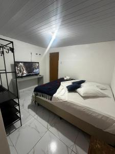 um quarto com uma cama e uma televisão em Pousada Dois Irmãos em Fernando de Noronha