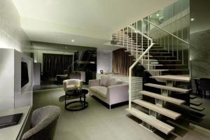 a living room with a spiral staircase in a house at Vivatel Kuala Lumpur in Kuala Lumpur