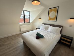 ein Schlafzimmer mit einem weißen Bett und einem grünen Gegenstand darauf in der Unterkunft Penthouse 2 bed 1 bathroom property in centre in Abingdon