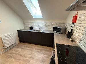eine Küche mit Spüle und Mikrowelle in der Unterkunft Penthouse 2 bed 1 bathroom property in centre in Abingdon