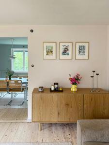 a living room with a wooden cabinet with flowers on it at Classic Swedish Wooden House Near Sea And Forest in Svängsta