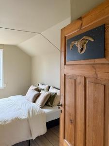 a bedroom with a bed and a door with a bird picture at Classic Swedish Wooden House Near Sea And Forest in Svängsta