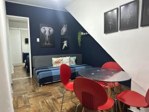 a living room with a table and red chairs at Exclusive House Barroca in Belo Horizonte