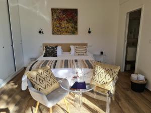 a bedroom with a bed and a table and chairs at entre sel et mer in LʼÉpine