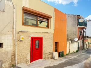 a red door on the side of a building at Loft Cosy Stone House in Konak