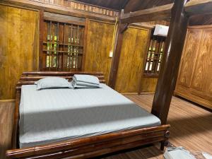 une chambre avec un lit dans une pièce aux murs en bois dans l'établissement Xóm Cảng homestay-Thac Ba lake, à Yên Bái