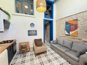 a living room with a couch and a kitchen at Loft Cosy Stone House in Konak