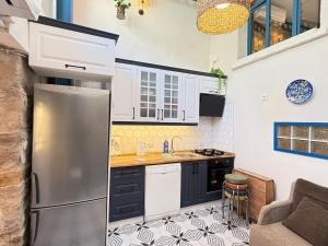 a kitchen with a stainless steel refrigerator in a kitchen at Loft Cosy Stone House in Konak