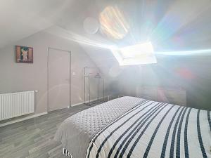 ein weißes Schlafzimmer mit einem Bett und einem Fenster in der Unterkunft Villa 363 - Détente en bord de Mer in Bray-Dunes