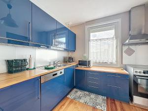 ブレ・デューンにあるVilla 363 - Détente en bord de Merの青いキャビネットと窓付きのキッチン