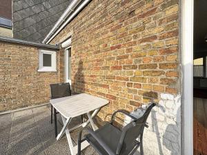 ブレ・デューンにあるVilla 363 - Détente en bord de Merのレンガの壁のパティオ(テーブル、椅子付)