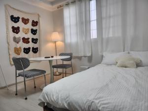 ein Schlafzimmer mit einem Bett und einem Tisch und Stühlen in der Unterkunft Suwon Stay 111 in Hagwanggyo-dong
