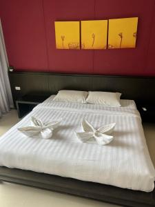 a bed with two white bows on top of it at Sea top room in Amphoe Koh Samui +10 photos