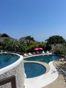 a pool with chairs and umbrellas in a resort at Sea top room in Amphoe Koh Samui