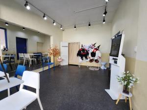 ein Zimmer mit Stühlen und Tischen und ein Zimmer mit zwei Kühen in der Unterkunft Suwon Stay 111 in Hagwanggyo-dong