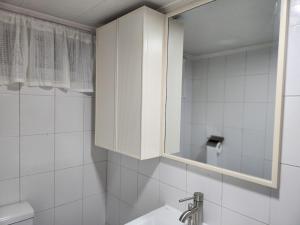 ein weißes Badezimmer mit Waschbecken und Spiegel in der Unterkunft Suwon Stay 111 in Hagwanggyo-dong + 38 Fotos
