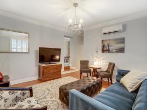 a living room with a blue couch and a tv at Liberty Street Retreat in Savannah