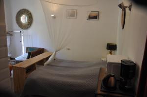 a bedroom with a bed and a desk with a television at location studio meublé avec jardin in Sorgues