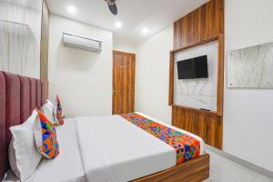 une chambre avec un lit blanc et une télévision dans l'établissement FabHotel Royal Metro, à Amritsar