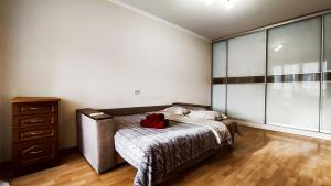 a bedroom with a bed with a red backpack on it at Олександрійський б-р 125 CityRooms in Bila Tserkva