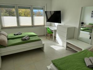 a bedroom with a bed and a desk and a television at Ferienwohnung Eyb in Ansbach