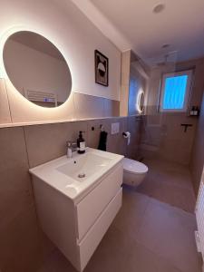 ein Badezimmer mit Waschbecken, Toilette und Spiegel in der Unterkunft Urban Home in Hannover