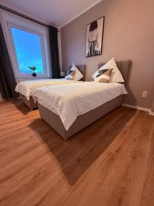 2 Betten in einem Schlafzimmer mit einem großen Fenster in der Unterkunft Urban Home in Hannover + 5 Fotos